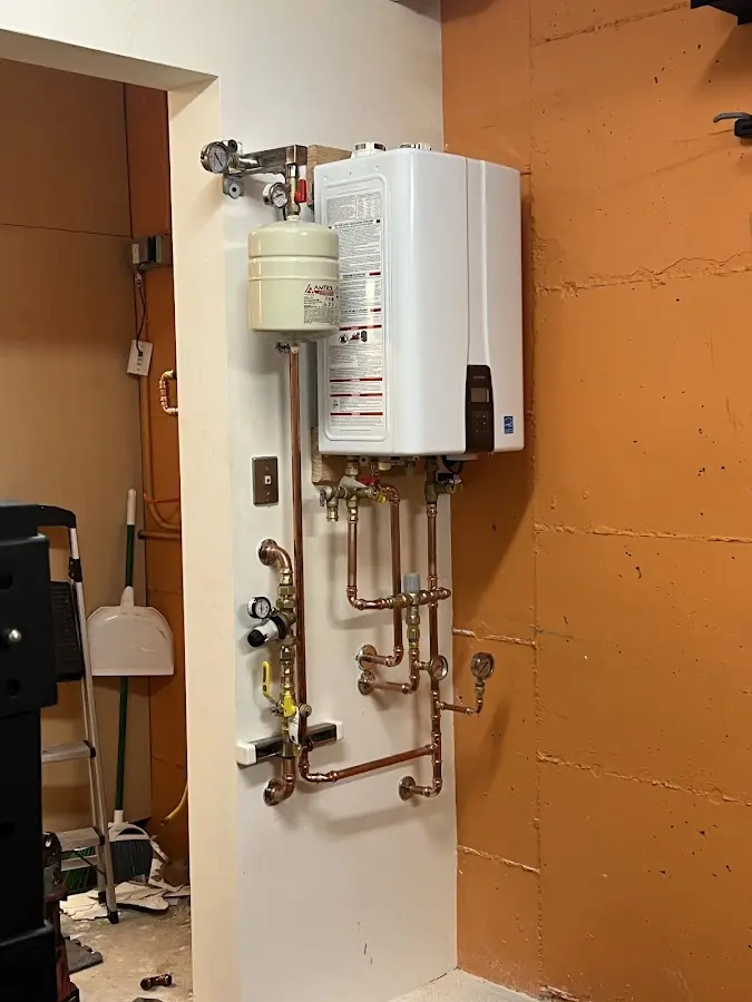 Plumbing technician inspecting water heater connections in Montrose